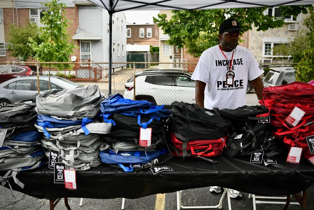 A man standing next to a table with several bags of luggage.