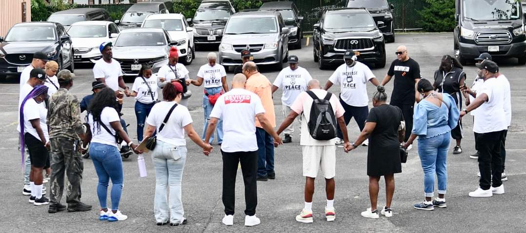 A group of people holding hands in the middle of a street.