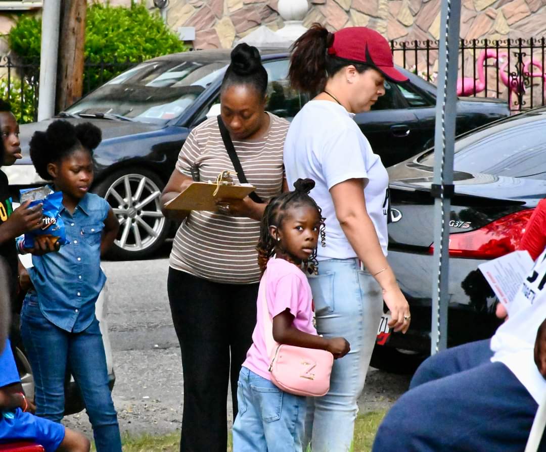 A group of people standing around on the street.