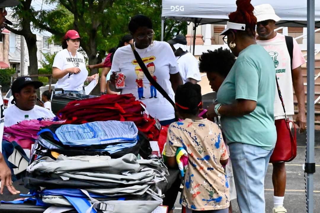 A group of people standing around a pile of clothes.