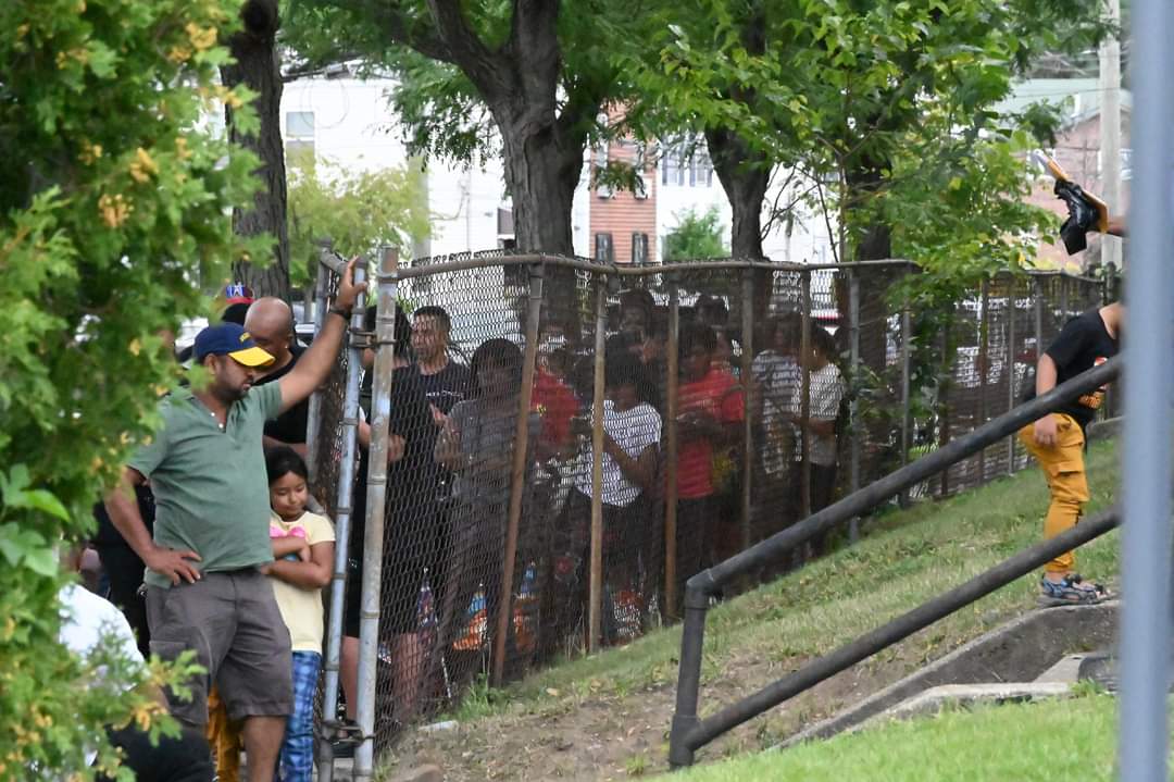 A man standing on top of a fence.