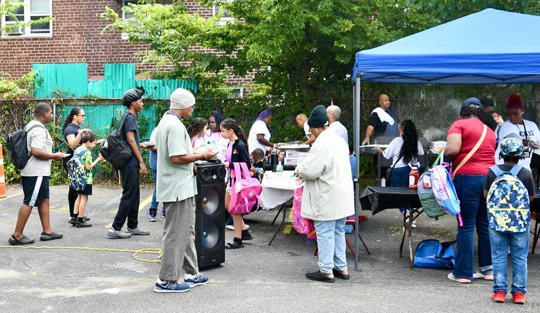 A group of people standing around an outdoor tent.