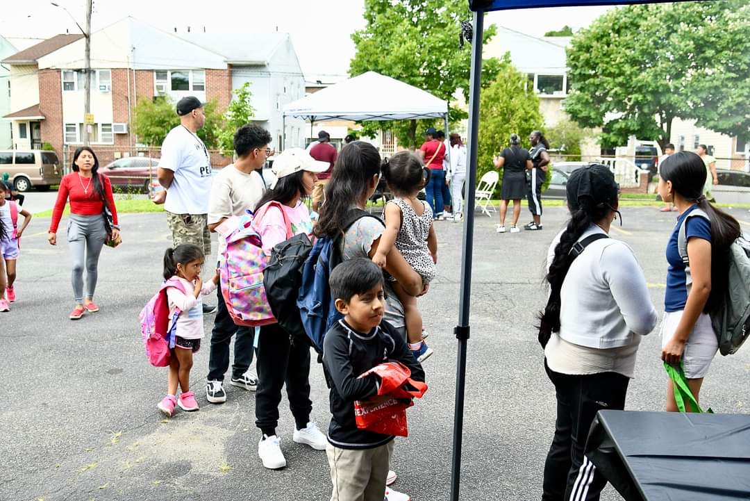 A group of people standing around in the street.