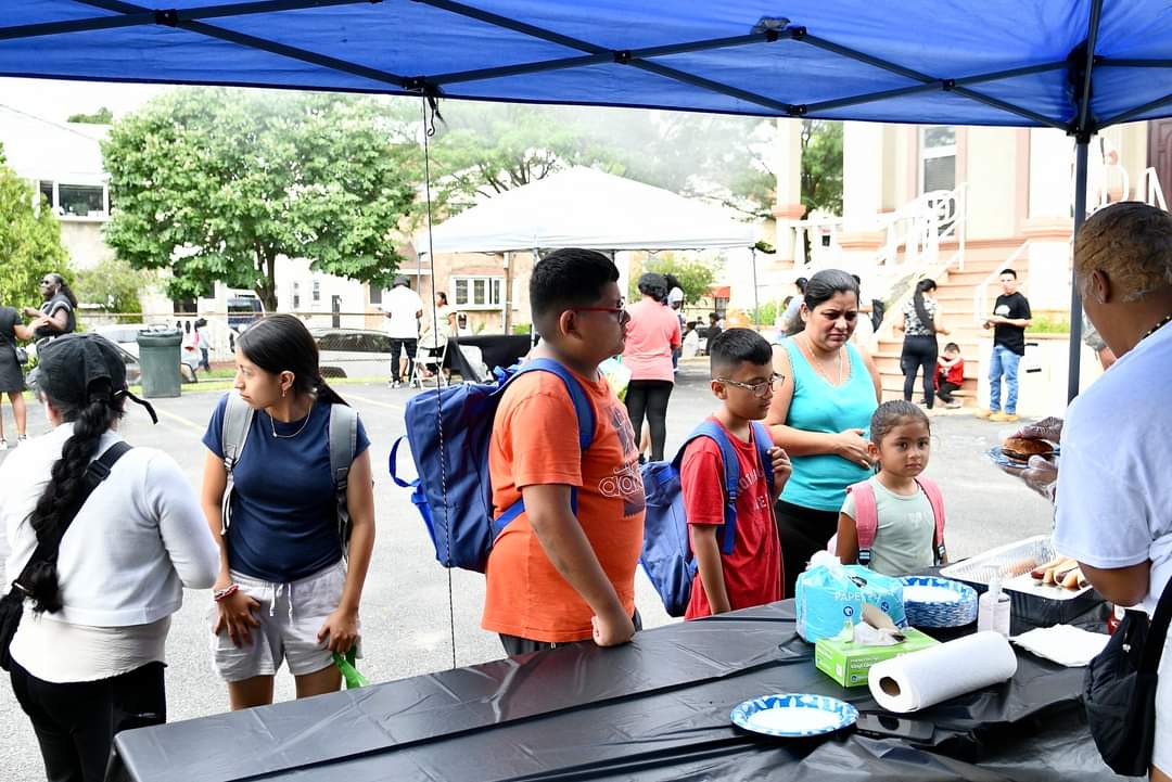 A group of people standing around an outdoor tent.