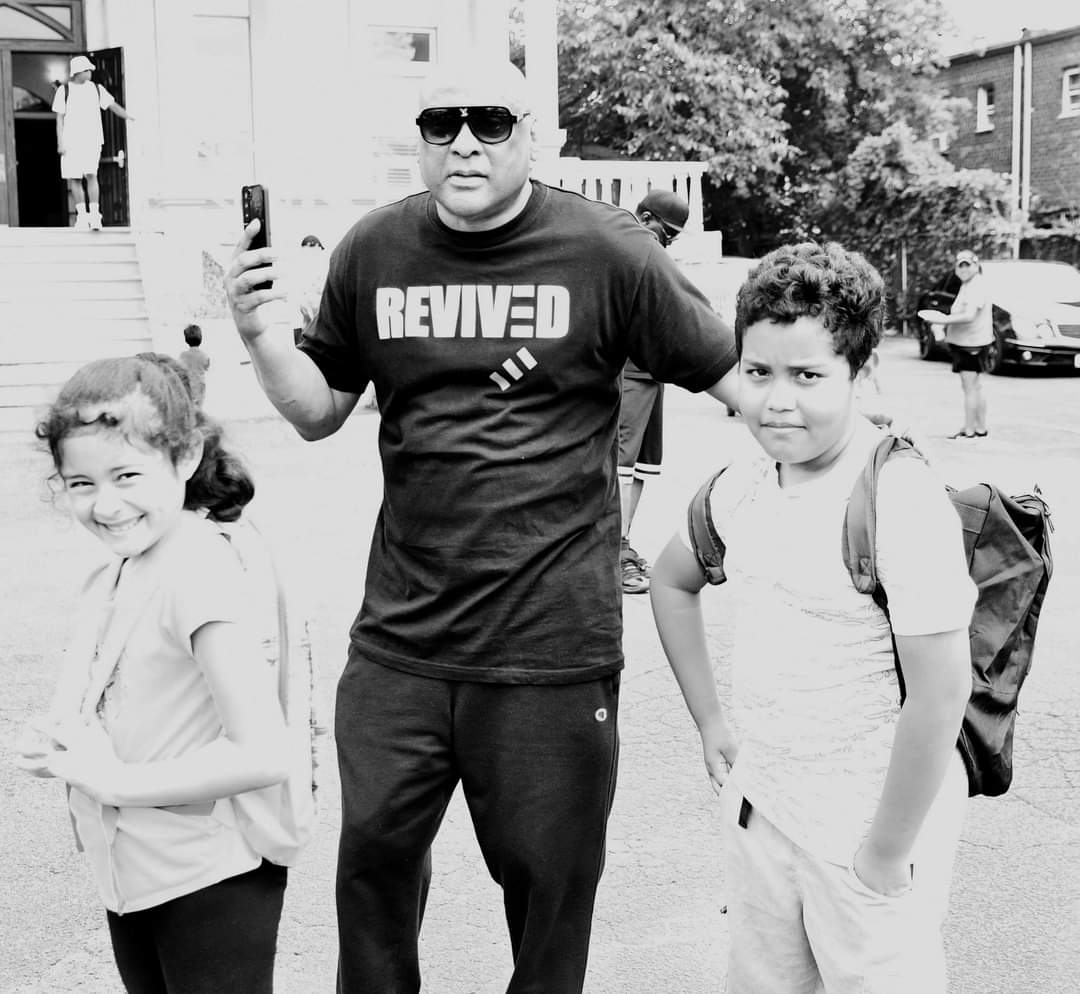 A man standing next to two young children.