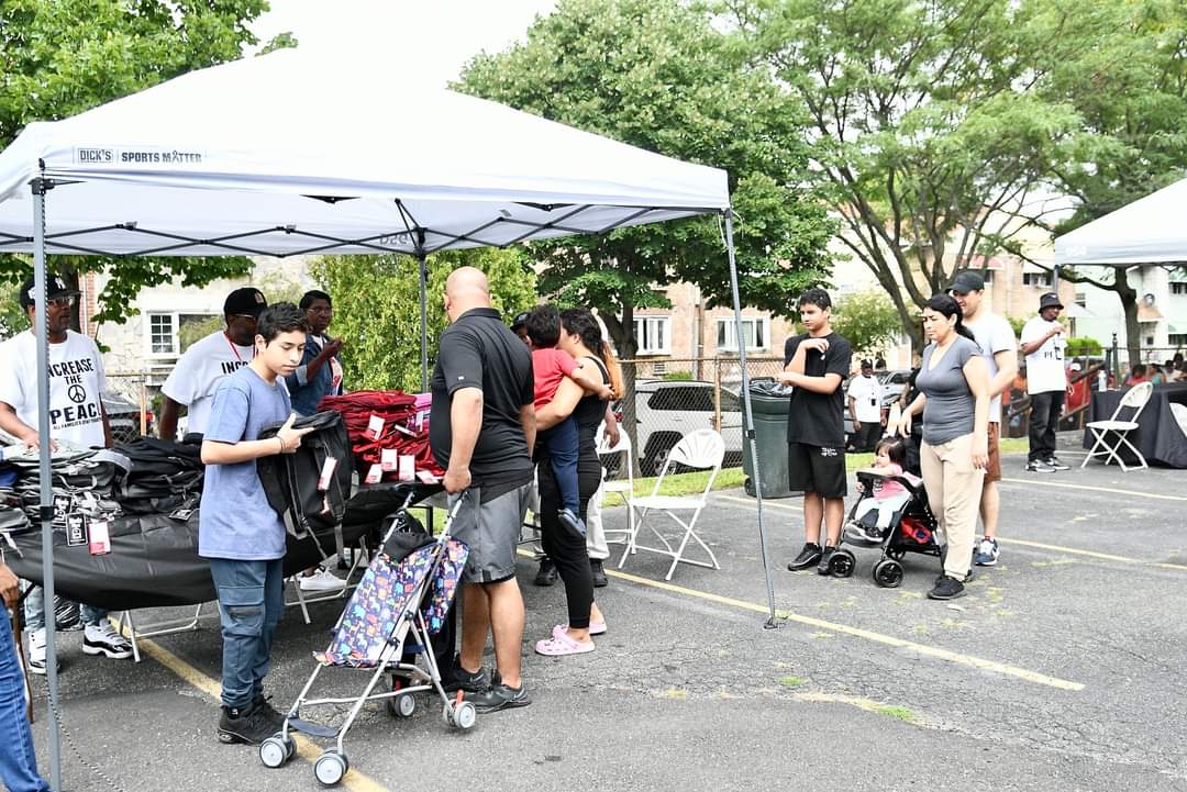 A group of people standing around an outdoor tent.